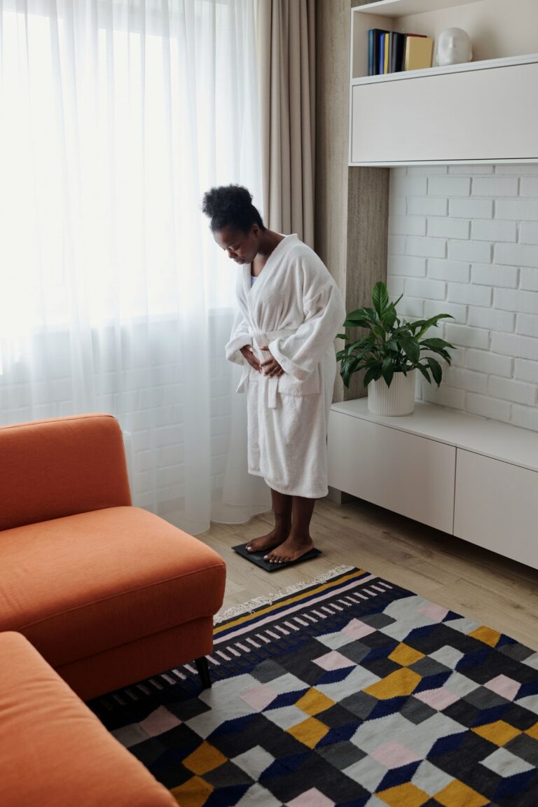 Woman checking her weight on a scale in a bright living room