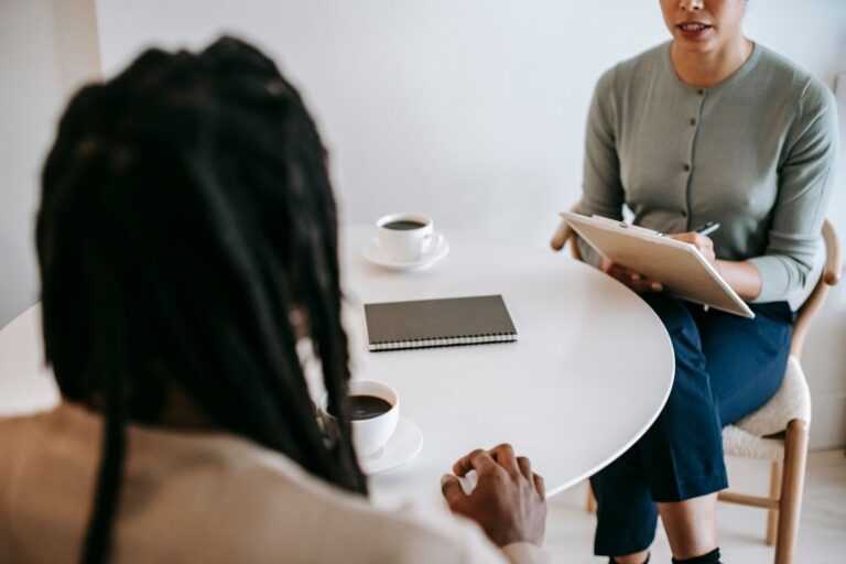 Therapist taking notes while speaking with a client