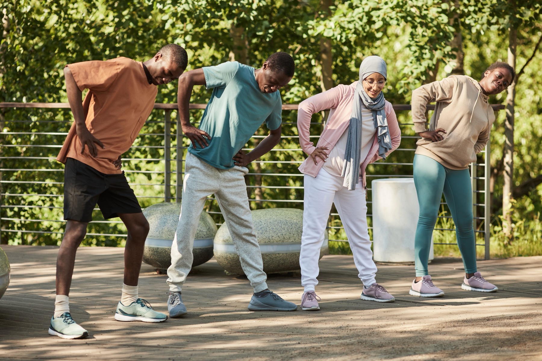 Four adults doing a group exercise session outdoors