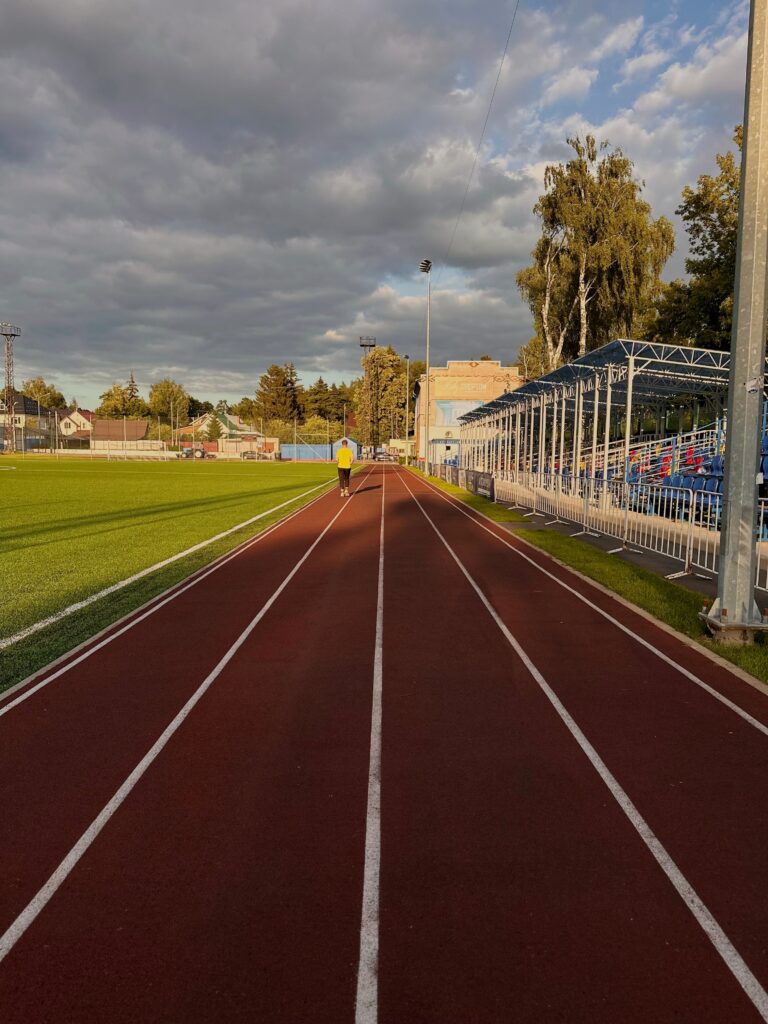 Runner jogging alone on an outdoor track at a sports stadium