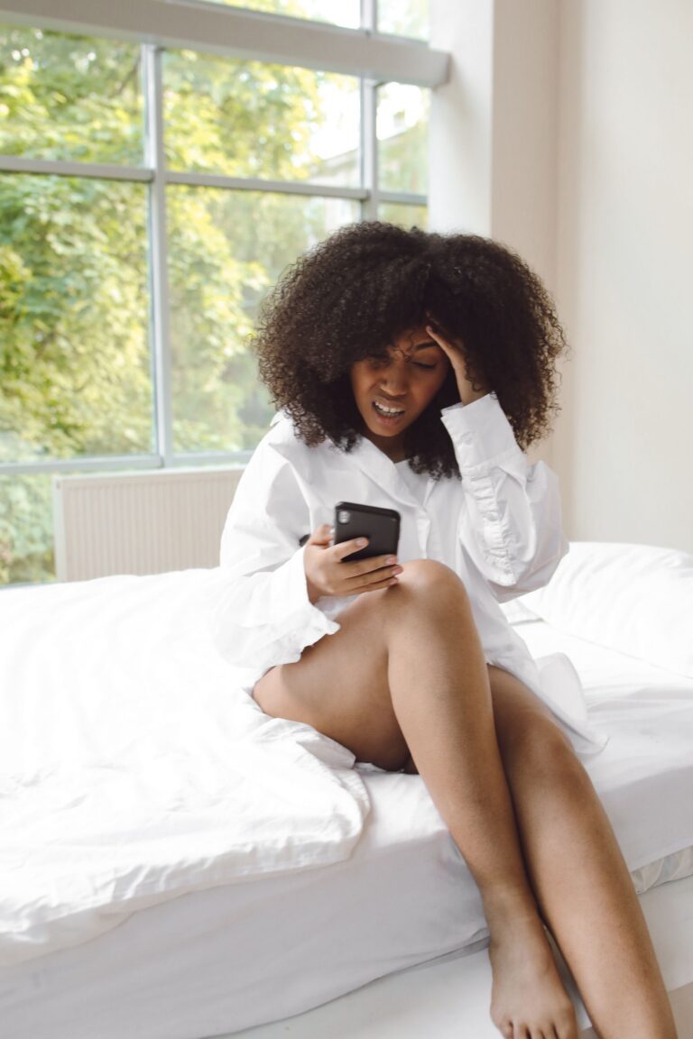 Woman feeling overwhelmed while reading health information on her phone