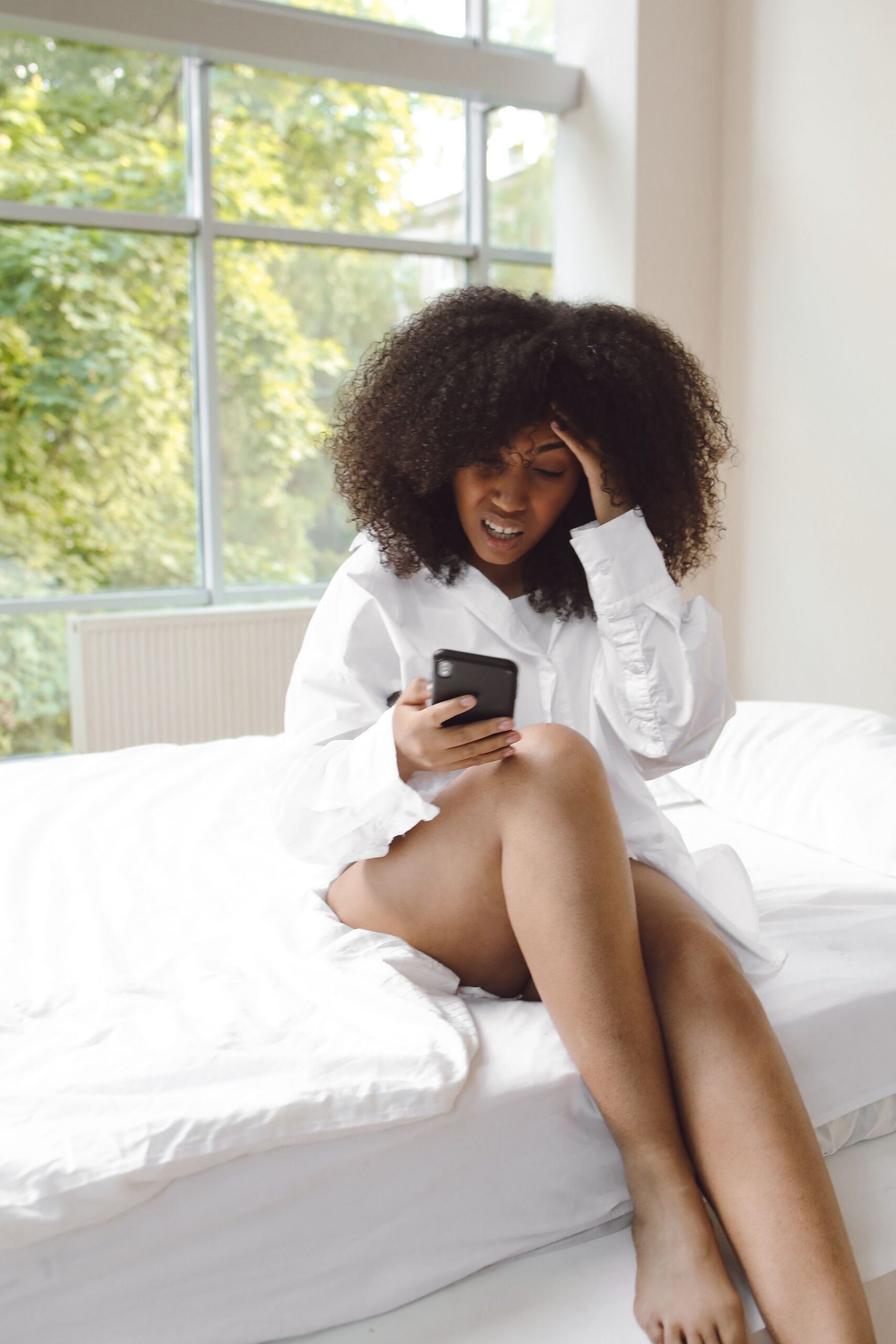 Woman feeling overwhelmed while reading health information on her phone