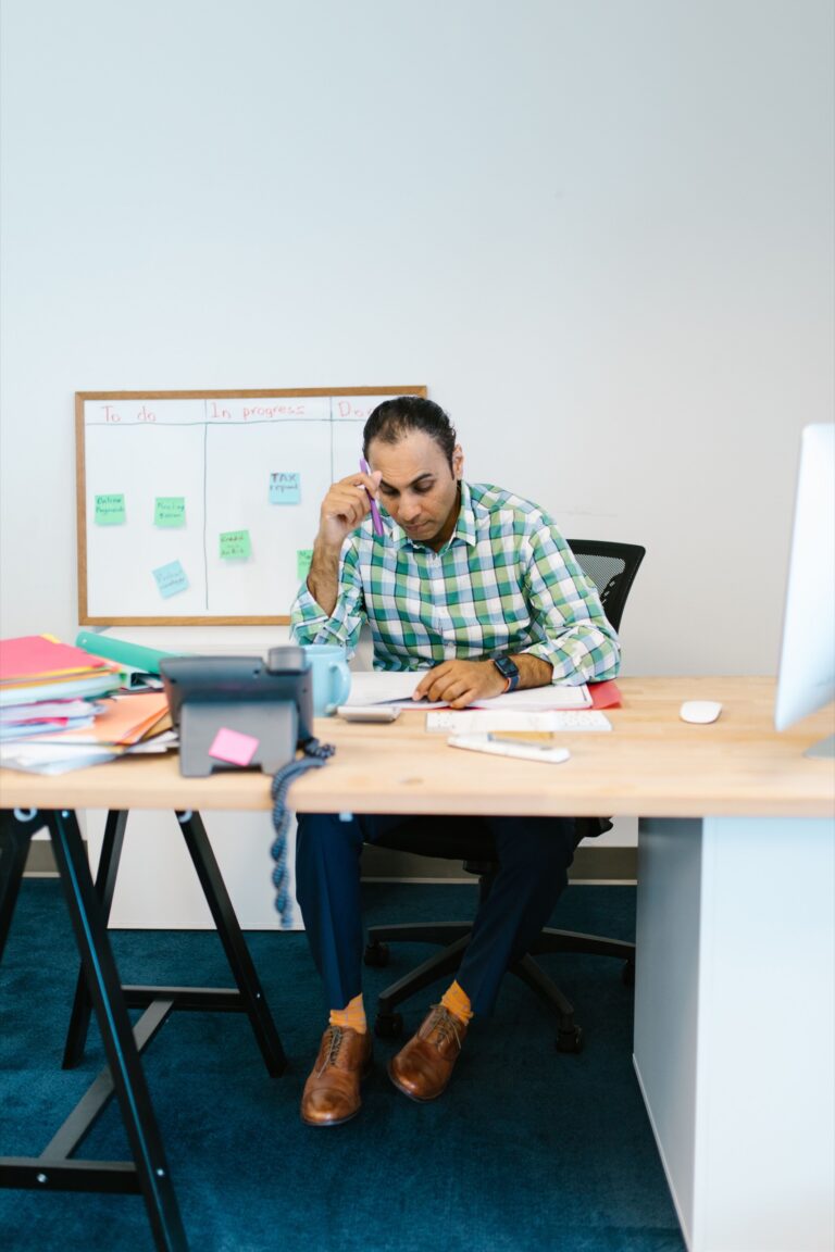 Professional reviewing notes at a desk while organizing several tasks