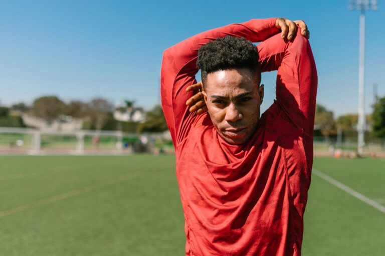 Athlete stretching outdoors on a sunny sports field