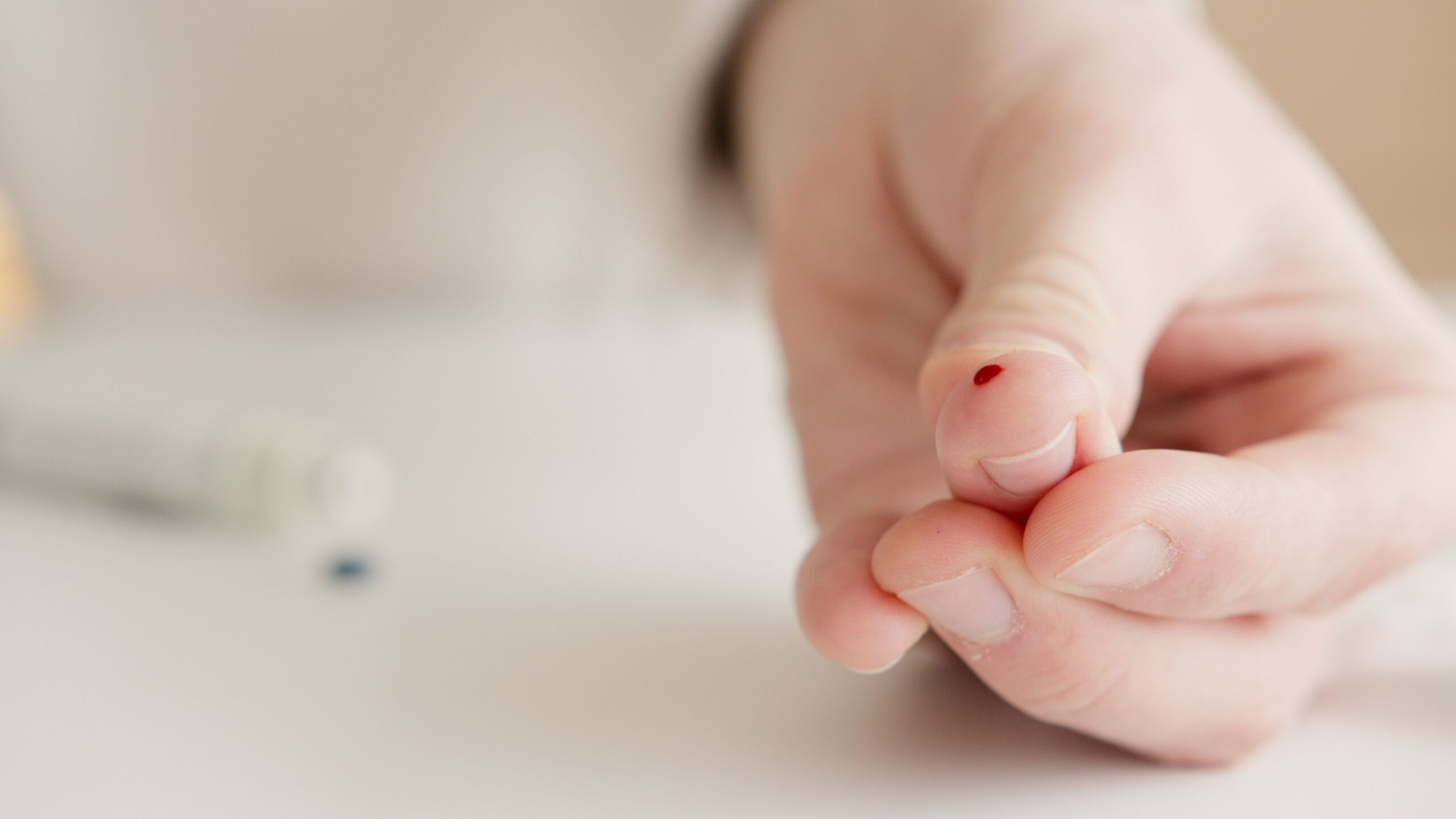 Person collecting a small finger-prick blood sample at home